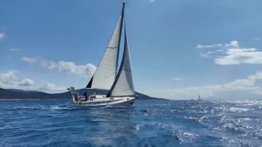 Bodrum, Hindi. 06 Nisan 2025: Ege Denizi 'nin mavi sularında, ünlü tatil beldesi Bodrum' un kıyılarında yelkenliler rüzgarlı havada yelken açıyor.