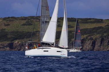 Bodrum, Hindi. 06 Nisan 2025: Ege Denizi 'nin mavi sularında, ünlü tatil beldesi Bodrum' un kıyılarında yelkenliler rüzgarlı havada yelken açıyor.