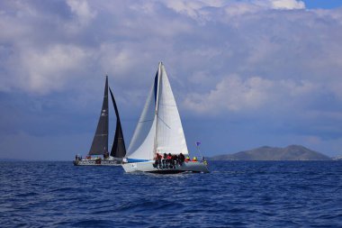 Bodrum, Hindi. 06 Nisan 2025: Ege Denizi 'nin mavi sularında, ünlü tatil beldesi Bodrum' un kıyılarında yelkenliler rüzgarlı havada yelken açıyor.