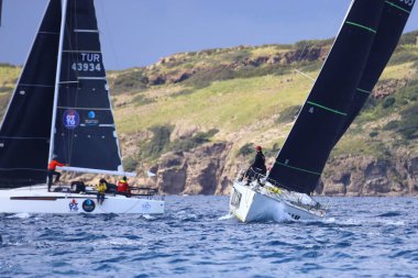 Bodrum, Hindi. 06 Nisan 2025: Ege Denizi 'nin mavi sularında, ünlü tatil beldesi Bodrum' un kıyılarında yelkenliler rüzgarlı havada yelken açıyor.