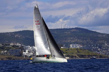Bodrum, Hindi. 06 Nisan 2025: Ege Denizi 'nin mavi sularında, ünlü tatil beldesi Bodrum' un kıyılarında yelkenliler rüzgarlı havada yelken açıyor.