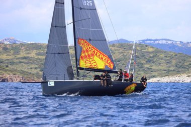 Bodrum, Hindi. 06 Nisan 2025: Ege Denizi 'nin mavi sularında, ünlü tatil beldesi Bodrum' un kıyılarında yelkenliler rüzgarlı havada yelken açıyor.