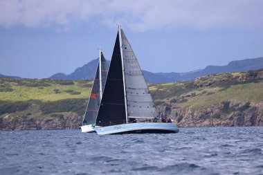 Bodrum, Hindi. 06 Nisan 2025: Ege Denizi 'nin mavi sularında, ünlü tatil beldesi Bodrum' un kıyılarında yelkenliler rüzgarlı havada yelken açıyor.