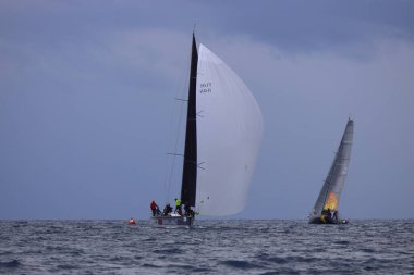 Bodrum, Hindi. 06 Nisan 2025: Ege Denizi 'nin mavi sularında, ünlü tatil beldesi Bodrum' un kıyılarında yelkenliler rüzgarlı havada yelken açıyor.