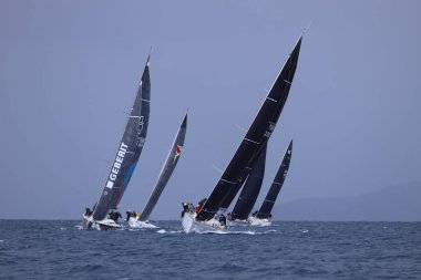 Bodrum, Hindi. 06 Nisan 2025: Ege Denizi 'nin mavi sularında, ünlü tatil beldesi Bodrum' un kıyılarında yelkenliler rüzgarlı havada yelken açıyor.