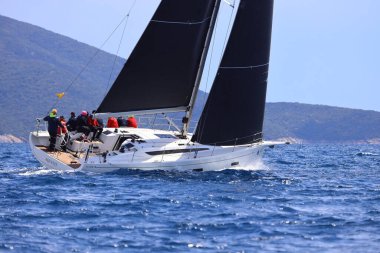 Bodrum, Hindi. 06 Nisan 2025: Ege Denizi 'nin mavi sularında, ünlü tatil beldesi Bodrum' un kıyılarında yelkenliler rüzgarlı havada yelken açıyor.