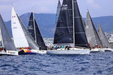 Bodrum, Hindi. 06 Nisan 2025: Ege Denizi 'nin mavi sularında, ünlü tatil beldesi Bodrum' un kıyılarında yelkenliler rüzgarlı havada yelken açıyor.