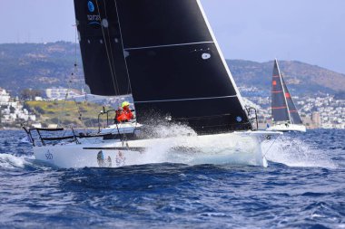 Bodrum, Hindi. 06 Nisan 2025: Ege Denizi 'nin mavi sularında, ünlü tatil beldesi Bodrum' un kıyılarında yelkenliler rüzgarlı havada yelken açıyor.