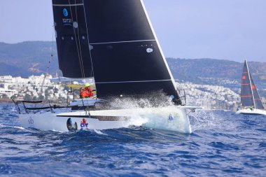 Bodrum, Hindi. 06 Nisan 2025: Ege Denizi 'nin mavi sularında, ünlü tatil beldesi Bodrum' un kıyılarında yelkenliler rüzgarlı havada yelken açıyor.