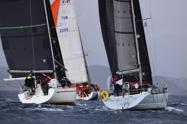 Bodrum, Hindi. 06 Nisan 2025: Ege Denizi 'nin mavi sularında, ünlü tatil beldesi Bodrum' un kıyılarında yelkenliler rüzgarlı havada yelken açıyor.