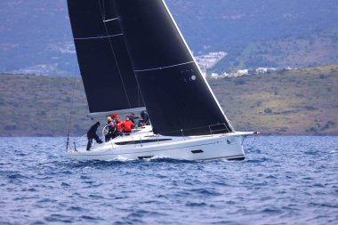 Bodrum, Hindi. 06 Nisan 2025: Ege Denizi 'nin mavi sularında, ünlü tatil beldesi Bodrum' un kıyılarında yelkenliler rüzgarlı havada yelken açıyor.