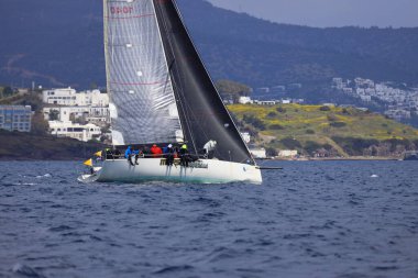 Bodrum, Hindi. 06 Nisan 2025: Ege Denizi 'nin mavi sularında, ünlü tatil beldesi Bodrum' un kıyılarında yelkenliler rüzgarlı havada yelken açıyor.