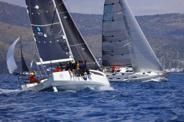 Bodrum, Hindi. 06 Nisan 2025: Ege Denizi 'nin mavi sularında, ünlü tatil beldesi Bodrum' un kıyılarında yelkenliler rüzgarlı havada yelken açıyor.