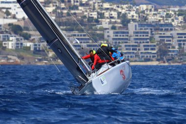 Bodrum, Hindi. 06 Nisan 2025: Ege Denizi 'nin mavi sularında, ünlü tatil beldesi Bodrum' un kıyılarında yelkenliler rüzgarlı havada yelken açıyor.