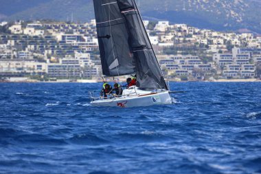 Bodrum, Hindi. 06 Nisan 2025: Ege Denizi 'nin mavi sularında, ünlü tatil beldesi Bodrum' un kıyılarında yelkenliler rüzgarlı havada yelken açıyor.