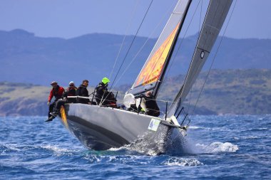 Bodrum, Hindi. 06 Nisan 2025: Ege Denizi 'nin mavi sularında, ünlü tatil beldesi Bodrum' un kıyılarında yelkenliler rüzgarlı havada yelken açıyor.