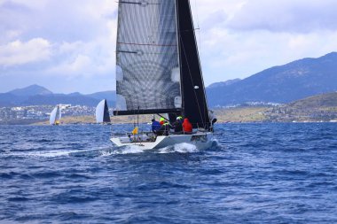 Bodrum, Hindi. 06 Nisan 2025: Ege Denizi 'nin mavi sularında, ünlü tatil beldesi Bodrum' un kıyılarında yelkenliler rüzgarlı havada yelken açıyor.