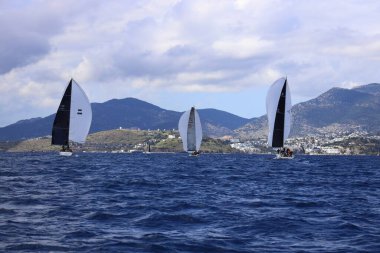 Bodrum, Hindi. 06 Nisan 2025: Ege Denizi 'nin mavi sularında, ünlü tatil beldesi Bodrum' un kıyılarında yelkenliler rüzgarlı havada yelken açıyor.