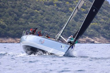 Bodrum, Hindi. 06 Nisan 2025: Ege Denizi 'nin mavi sularında, ünlü tatil beldesi Bodrum' un kıyılarında yelkenliler rüzgarlı havada yelken açıyor.