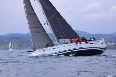 Bodrum, Hindi. 06 Nisan 2025: Ege Denizi 'nin mavi sularında, ünlü tatil beldesi Bodrum' un kıyılarında yelkenliler rüzgarlı havada yelken açıyor.
