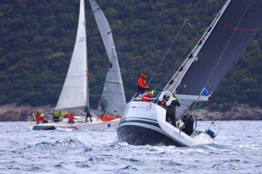 Bodrum, Hindi. 06 Nisan 2025: Ege Denizi 'nin mavi sularında, ünlü tatil beldesi Bodrum' un kıyılarında yelkenliler rüzgarlı havada yelken açıyor.