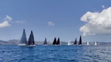 Bodrum, Hindi. 27 Nisan 2025: Ege Denizi 'nin mavi sularında, ünlü tatil beldesi Bodrum' un kıyılarında yelkenliler rüzgarlı havada yelken açıyor.