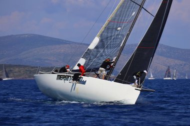 Bodrum, Hindi. 26 Nisan 2025: Yelkenliler Ege Denizi 'nin mavi sularında, ünlü tatil beldesi Bodrum' un kıyılarında rüzgarlı havada yelken açıyor..