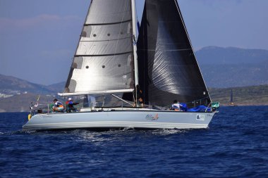 Bodrum, Hindi. 26 Nisan 2025: Yelkenliler Ege Denizi 'nin mavi sularında, ünlü tatil beldesi Bodrum' un kıyılarında rüzgarlı havada yelken açıyor..