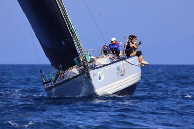 Bodrum, Hindi. 26 Nisan 2025: Yelkenliler Ege Denizi 'nin mavi sularında, ünlü tatil beldesi Bodrum' un kıyılarında rüzgarlı havada yelken açıyor..