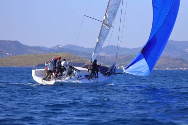 Bodrum, Hindi. 26 Nisan 2025: Yelkenliler Ege Denizi 'nin mavi sularında, ünlü tatil beldesi Bodrum' un kıyılarında rüzgarlı havada yelken açıyor..