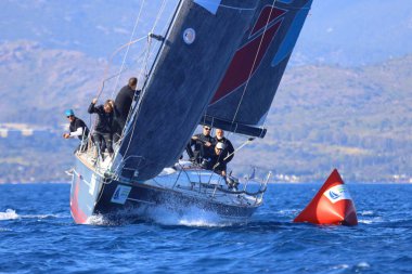 Bodrum, Hindi. 26 Nisan 2025: Yelkenliler Ege Denizi 'nin mavi sularında, ünlü tatil beldesi Bodrum' un kıyılarında rüzgarlı havada yelken açıyor..