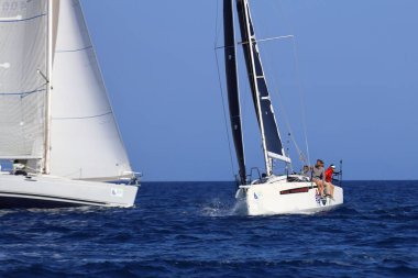 Bodrum, Hindi. 26 Nisan 2025: Yelkenliler Ege Denizi 'nin mavi sularında, ünlü tatil beldesi Bodrum' un kıyılarında rüzgarlı havada yelken açıyor..