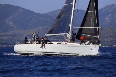 Bodrum, Hindi. 26 Nisan 2025: Yelkenliler Ege Denizi 'nin mavi sularında, ünlü tatil beldesi Bodrum' un kıyılarında rüzgarlı havada yelken açıyor..