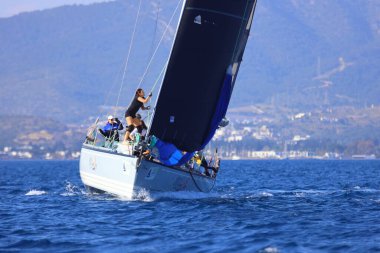 Bodrum, Hindi. 26 Nisan 2025: Yelkenliler Ege Denizi 'nin mavi sularında, ünlü tatil beldesi Bodrum' un kıyılarında rüzgarlı havada yelken açıyor..