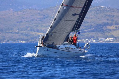 Bodrum, Hindi. 26 Nisan 2025: Yelkenliler Ege Denizi 'nin mavi sularında, ünlü tatil beldesi Bodrum' un kıyılarında rüzgarlı havada yelken açıyor..