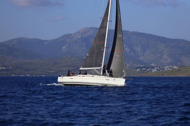 Bodrum, Hindi. 26 Nisan 2025: Yelkenliler Ege Denizi 'nin mavi sularında, ünlü tatil beldesi Bodrum' un kıyılarında rüzgarlı havada yelken açıyor..