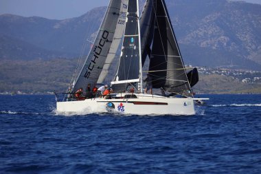 Bodrum, Hindi. 26 Nisan 2025: Yelkenliler Ege Denizi 'nin mavi sularında, ünlü tatil beldesi Bodrum' un kıyılarında rüzgarlı havada yelken açıyor..