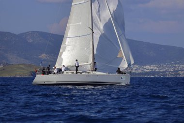 Bodrum, Hindi. 26 Nisan 2025: Yelkenliler Ege Denizi 'nin mavi sularında, ünlü tatil beldesi Bodrum' un kıyılarında rüzgarlı havada yelken açıyor..