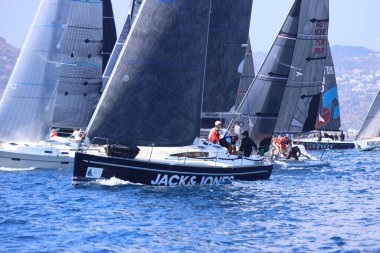 Bodrum, Hindi. 27 Nisan 2025: Ege Denizi 'nin mavi sularında, ünlü tatil beldesi Bodrum' un kıyılarında yelkenliler rüzgarlı havada yelken açıyor.
