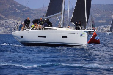 Bodrum, Hindi. 27 Nisan 2025: Ege Denizi 'nin mavi sularında, ünlü tatil beldesi Bodrum' un kıyılarında yelkenliler rüzgarlı havada yelken açıyor.