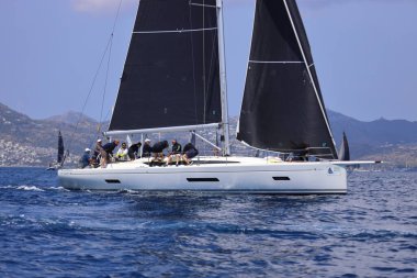 Bodrum, Hindi. 27 Nisan 2025: Ege Denizi 'nin mavi sularında, ünlü tatil beldesi Bodrum' un kıyılarında yelkenliler rüzgarlı havada yelken açıyor.