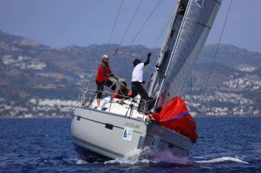 Bodrum, Hindi. 27 Nisan 2025: Ege Denizi 'nin mavi sularında, ünlü tatil beldesi Bodrum' un kıyılarında yelkenliler rüzgarlı havada yelken açıyor.
