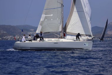 Bodrum, Hindi. 27 Nisan 2025: Ege Denizi 'nin mavi sularında, ünlü tatil beldesi Bodrum' un kıyılarında yelkenliler rüzgarlı havada yelken açıyor.