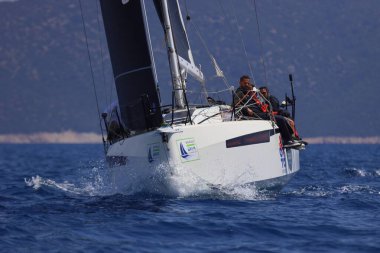 Bodrum, Hindi. 27 Nisan 2025: Ege Denizi 'nin mavi sularında, ünlü tatil beldesi Bodrum' un kıyılarında yelkenliler rüzgarlı havada yelken açıyor.