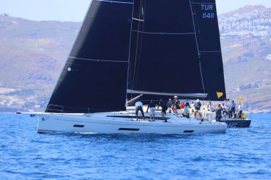 Bodrum, Hindi. 27 Nisan 2025: Ege Denizi 'nin mavi sularında, ünlü tatil beldesi Bodrum' un kıyılarında yelkenliler rüzgarlı havada yelken açıyor.