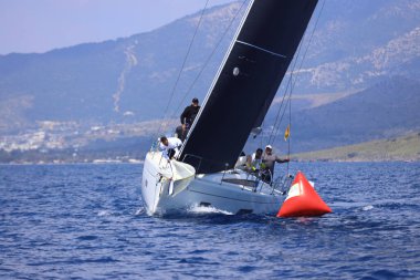 Bodrum, Hindi. 27 Nisan 2025: Ege Denizi 'nin mavi sularında, ünlü tatil beldesi Bodrum' un kıyılarında yelkenliler rüzgarlı havada yelken açıyor.