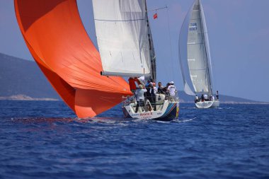 Bodrum, Hindi. 27 Nisan 2025: Ege Denizi 'nin mavi sularında, ünlü tatil beldesi Bodrum' un kıyılarında yelkenliler rüzgarlı havada yelken açıyor.