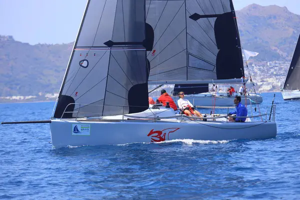 Bodrum, Hindi. 27 Nisan 2025: Ege Denizi 'nin mavi sularında, ünlü tatil beldesi Bodrum' un kıyılarında yelkenliler rüzgarlı havada yelken açıyor.