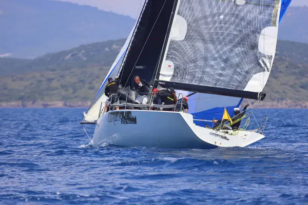 Bodrum, Hindi. 27 Nisan 2025: Ege Denizi 'nin mavi sularında, ünlü tatil beldesi Bodrum' un kıyılarında yelkenliler rüzgarlı havada yelken açıyor.