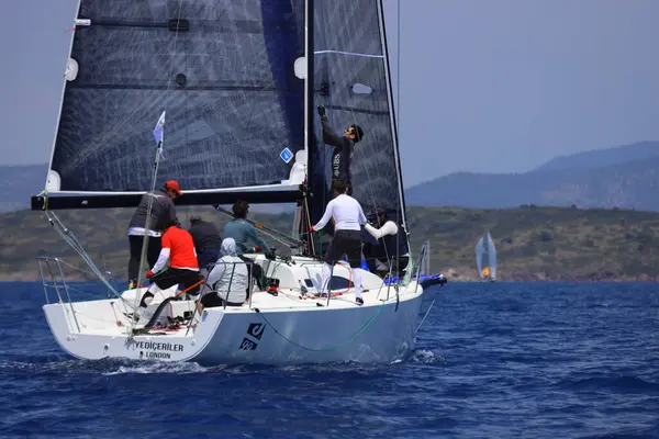 Bodrum, Hindi. 27 Nisan 2025: Ege Denizi 'nin mavi sularında, ünlü tatil beldesi Bodrum' un kıyılarında yelkenliler rüzgarlı havada yelken açıyor.